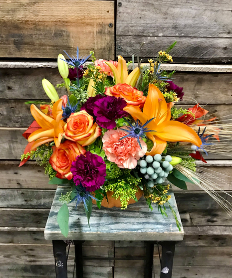 fall toned flowers in pumpkin vase