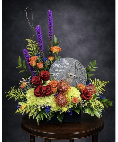 cream and white floral arrangement with gardens stone
