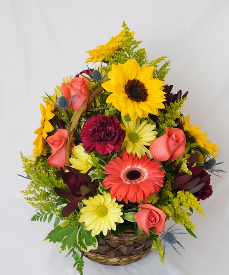 Fresh cut flowers fill a wicker basket in a variation of colors and scents 