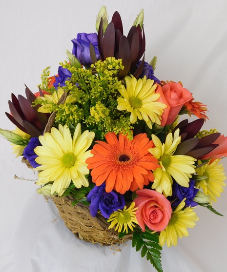 Fresh cut flowers fill a wicker basket in a variation of colors and scents 