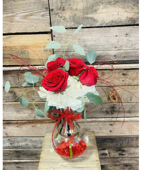 red roses with white hydrangea in glass and silver vase