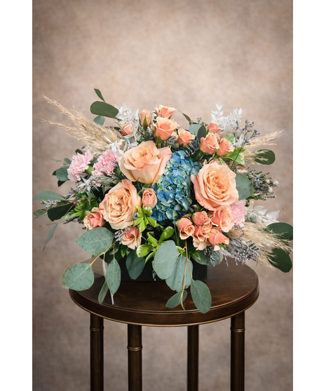 pampas grasses and white bleached ruscus with fresh blue hydrangeas, shimmer roses, peach spray roses, pink carnations, caspia and eucalyptus to the perfect centerpiece. 