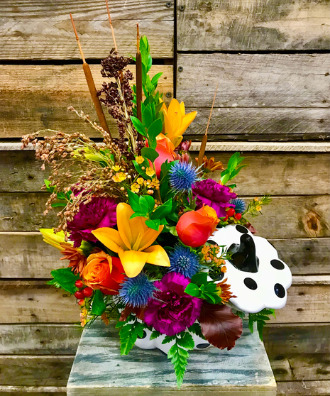 fall-toned floral arrangement in striped pumpkin