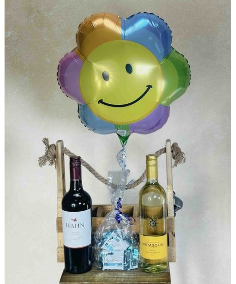 bottle of wine with chocolates and smiley face balloon