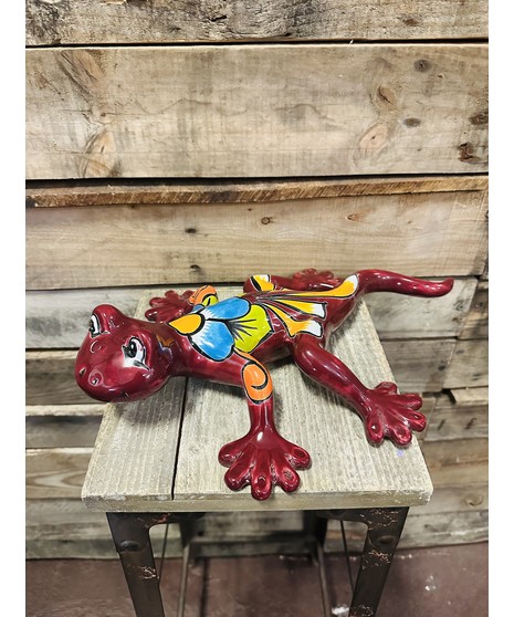 red Talavera tadpole with colorful flower design on back, resting on wooden crate